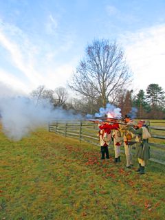 2013: Reenactors in British and American military dress honor the fallen with memorial volleys on New Year's Day, 2014. They stand next to the Mercer Oak on the battlefield, where legend says the severely wounded general lay while the fighting continued. (The current tree is a descendant of the original, which was felled by strong winds in 2000.)